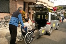 車いすの高齢者を乗用車に乗せている光景